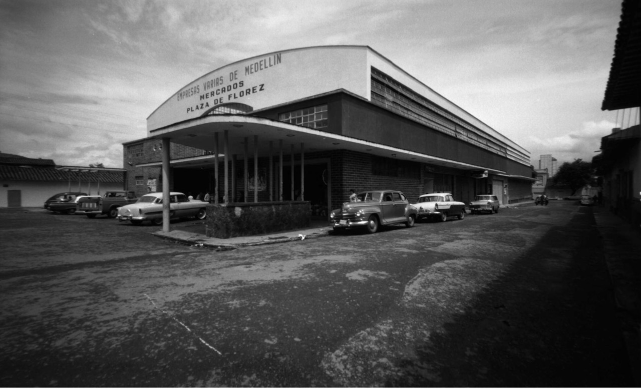 Plaza de Flórez, ubicada en el centro de Medellín, fue levantada en el año 1891 en terrenos donados por el señor Rafael Flórez. Cuartel de policía, circo de toros, convento, patronato de obreros y escuela de niñas; han sido muchos de los usos que se le dieron a la construcción. Solo hasta 1955 se inauguró como la primera Plaza de mercado cubierta que se edificó en Colombia. Las Empresas Varias fueron las encargadas de la organización y el manejo de plazas de mercado desde 1964 hasta 1998. Fue declarada como Patrimonio Histórico y Cultural de Medellín, en el año 2000. Carvajal Pérez, Gabriel (1969). Archivo Digital Biblioteca Pública Piloto. Disponible en: https://bibliotecapiloto.janium.net/janium-bin/janium_zui.pl?jzd=/janium/Fotos/BPP-F-014/0958.jzd&fn=13958