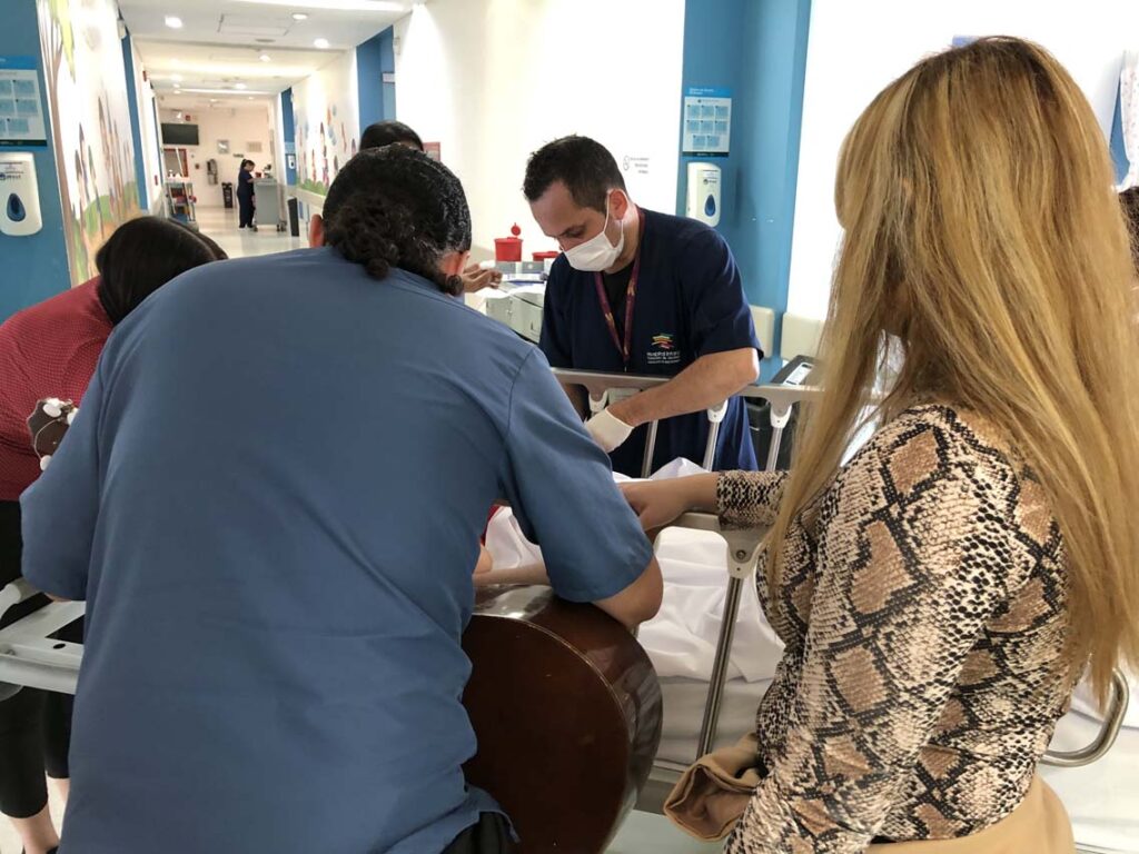 Elkin se acerca a la cama de David en el quinto piso del Hospital Infantil Concejo de Medellín.