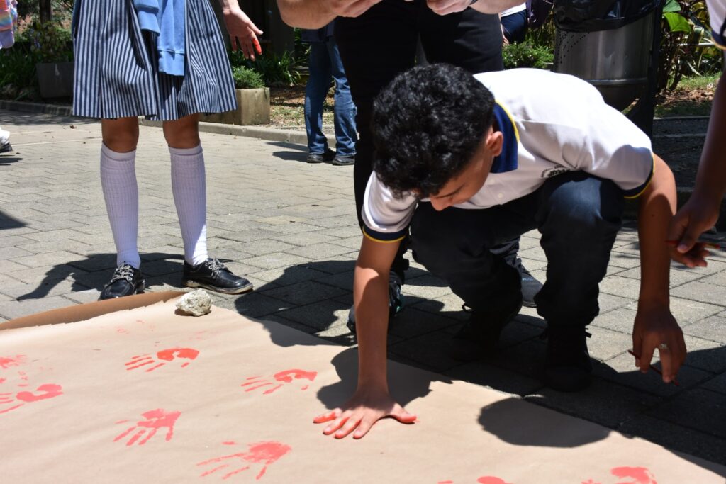 Jóvenes pintando manos rojas
