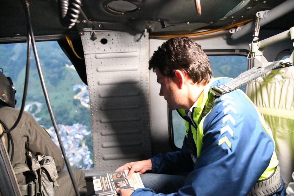 Imagen funcionario repartiendo volantes en helicóptero