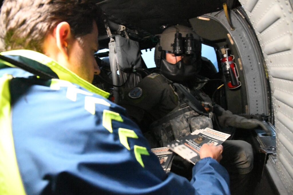 Imagen funcionario repartiendo volantes en helicóptero 2
