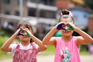 Imagen niñas haciendo corazones