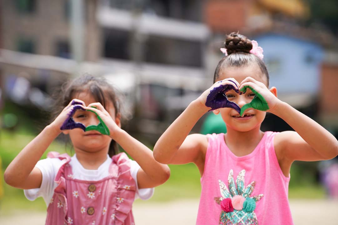 Imagen niñas haciendo corazones