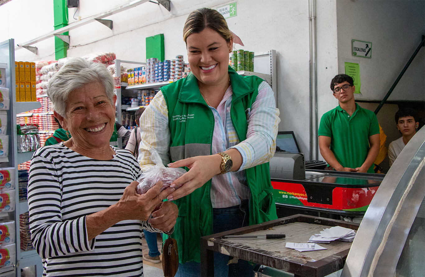 Imagen señora en la caja con el Bono Alimentario 2025