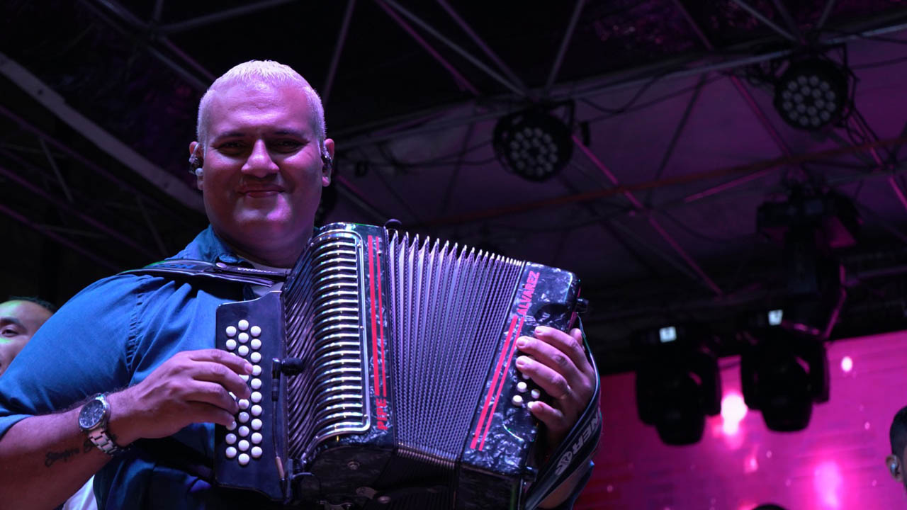 Imagen muestra cultural con acordeonero en escenario