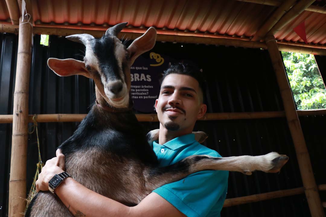 Imagen cabra y cuidador granja