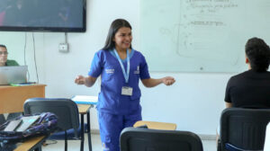 Imagen de funcionaria de la secretaría de salud en salón de clases
