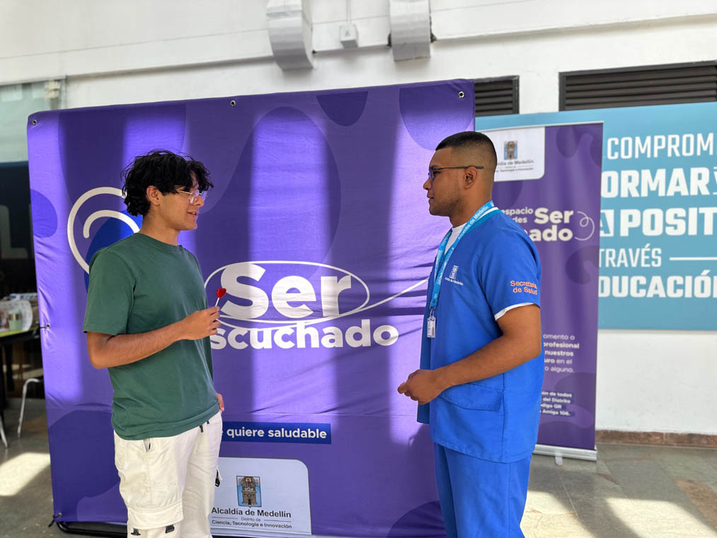 Imagen de funcionario de la secretaría de salud atendiendo a joven