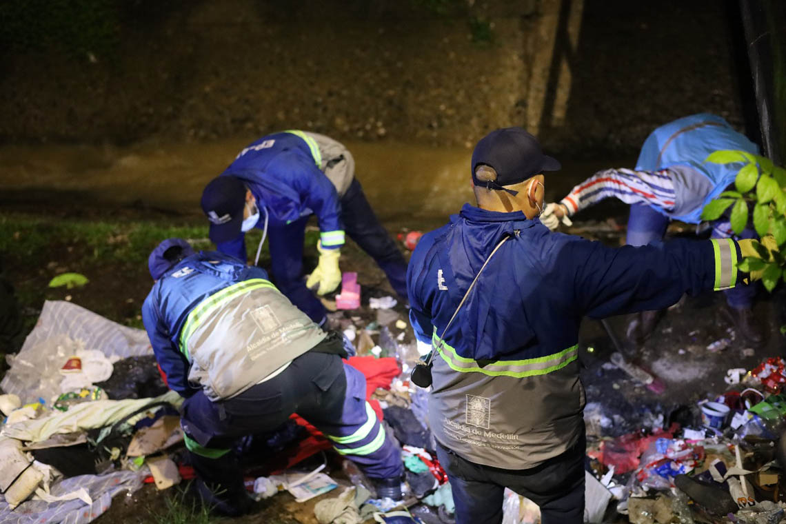 Imagen de intervención de funcionarios revisando basuras en canalización