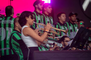 Imagen de niña tocando trompeta con barristas