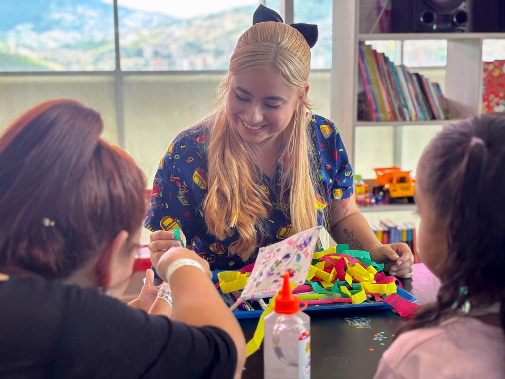 Imagen de facilitadora haciendo manualidades con menores
