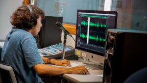 Imagen de joven editan audios en computador