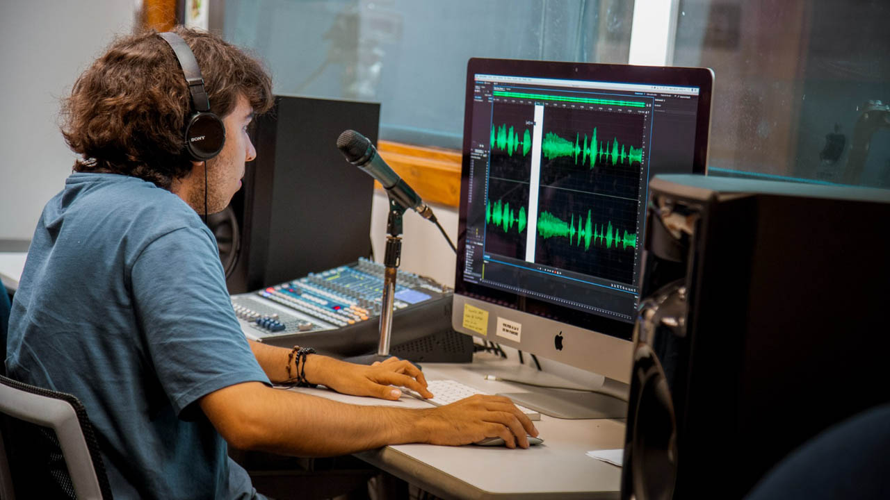 Imagen de joven editan audios en computador