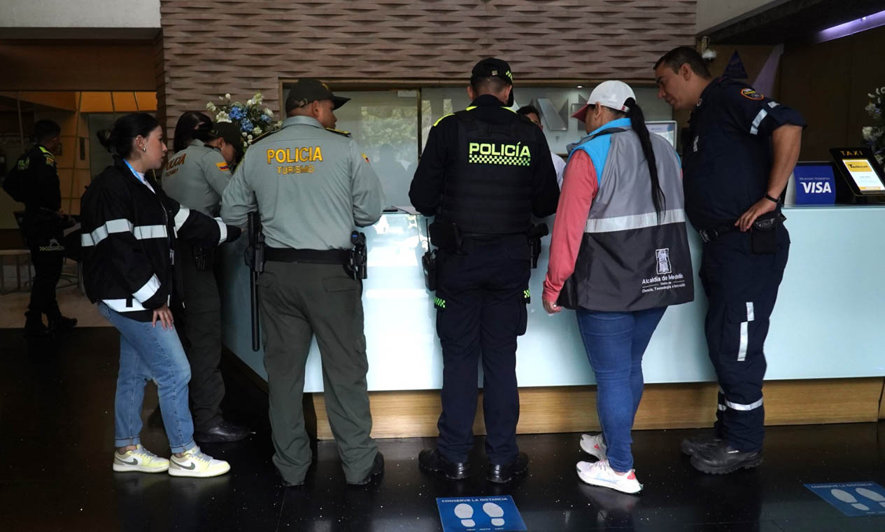 Imagen de policía y funcionarios en lobby de hotel