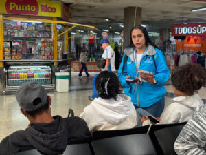 Imagen de funcionaria entregando información a ciudadanos en Terminal de Transporte