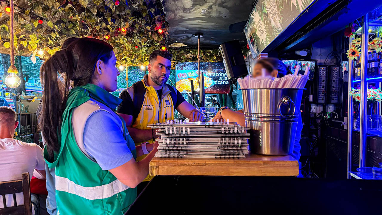 Imagen de funcionarios asesorando a comerciante de la 70