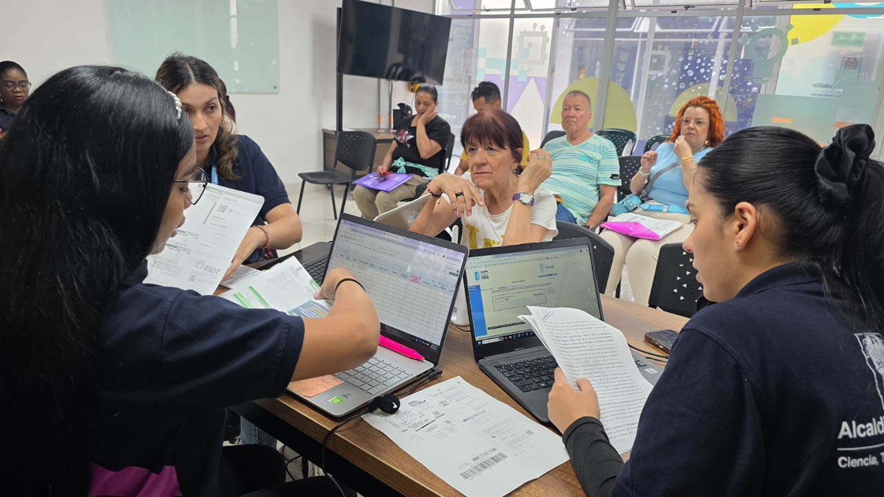 Imagen de funcionarios de Isvimed asesorando a ciudadana