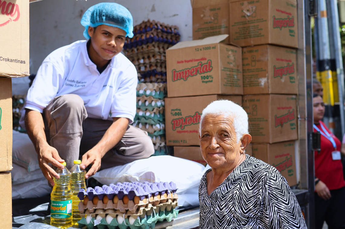 Imagen de adulto mayor recibiendo paquete alimentario