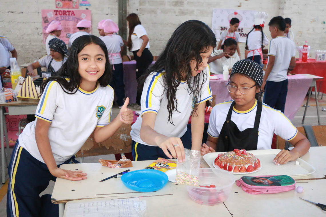Imagen de equipo niñas decorando pastel en concurso Con una pizca de matemática