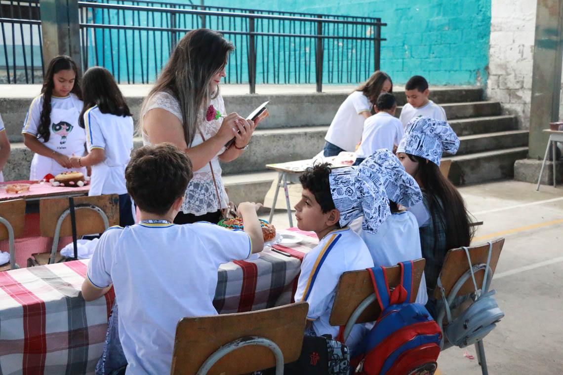 Imagen de jueza con niñas participantes en concurso Con una pizca de matemática