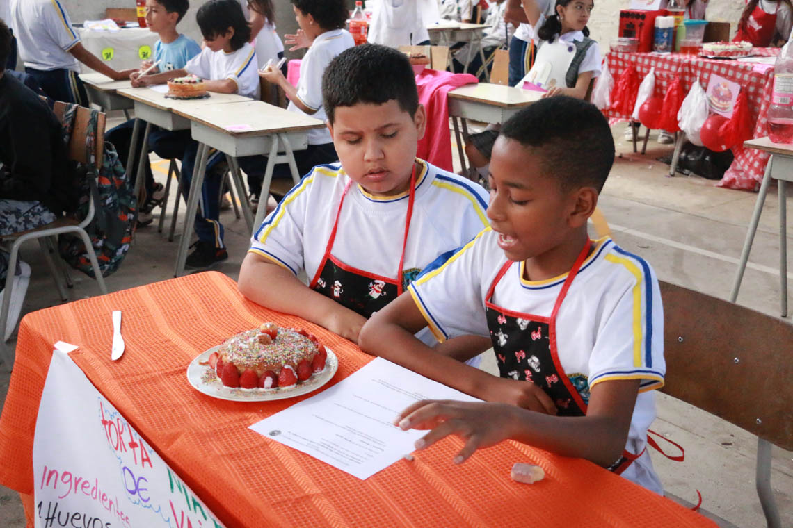 Imagen de pareja de niños resolviendo puebas en concurso Con una pizca de matemática