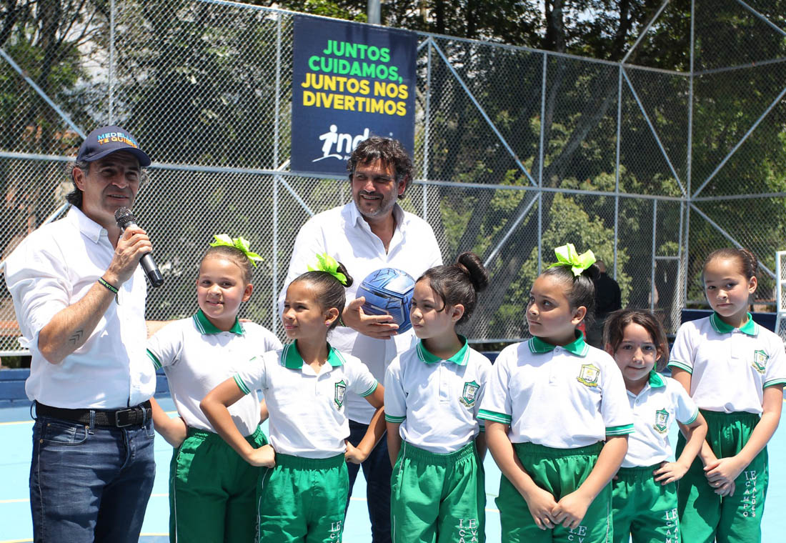 Imagen del Alcalde con director del Inder y niños en escenario deportivo