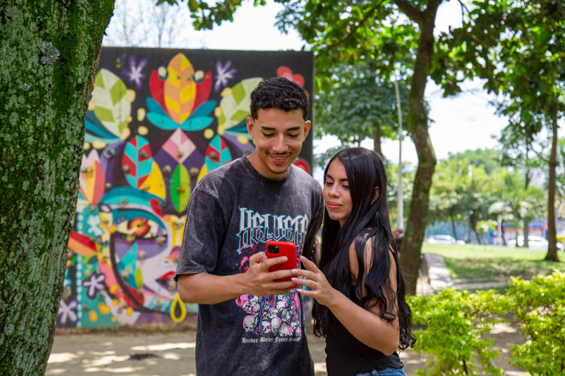 Imagen de dos ciudadanos observando un celular