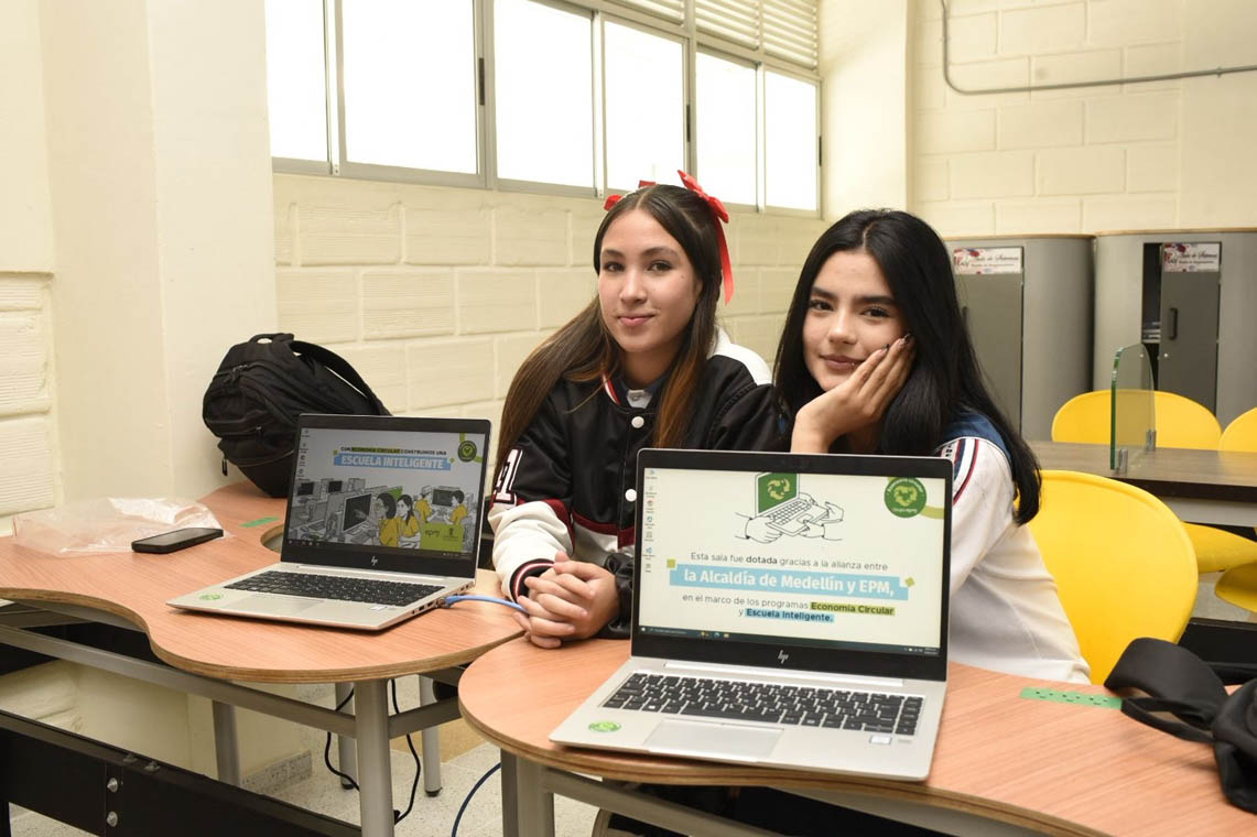 Imagen de dos estudiantes con computadores