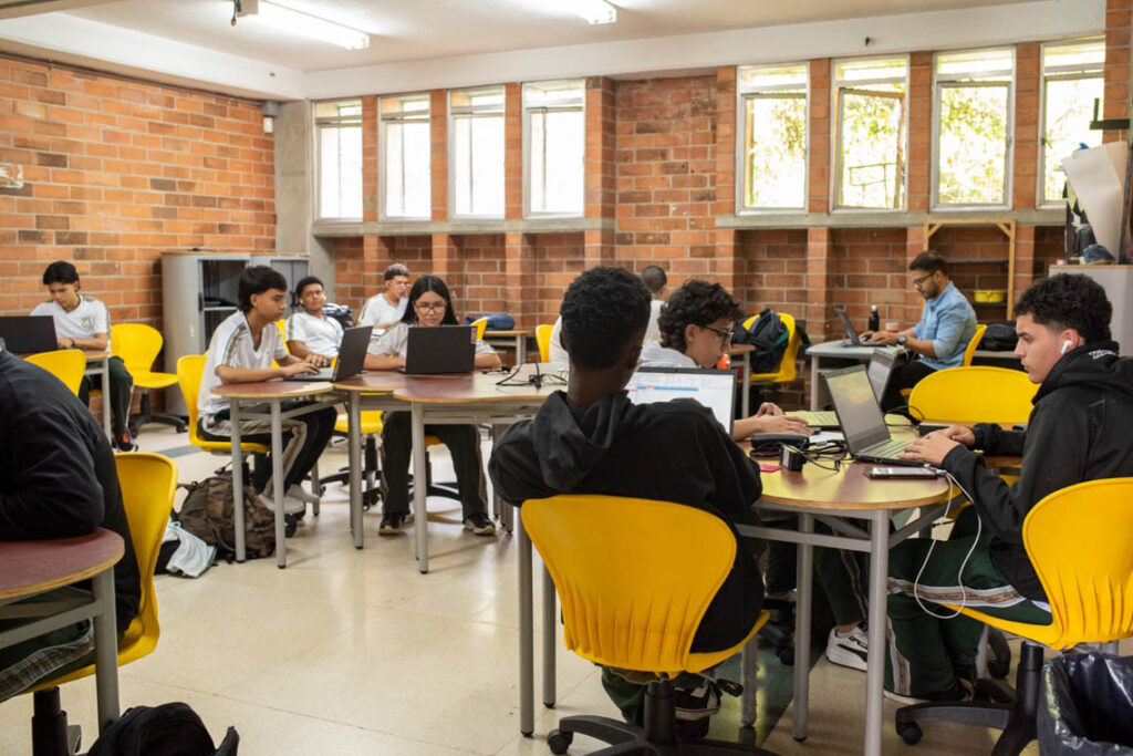 Imagen de estudiantes en salón de colegio de clases