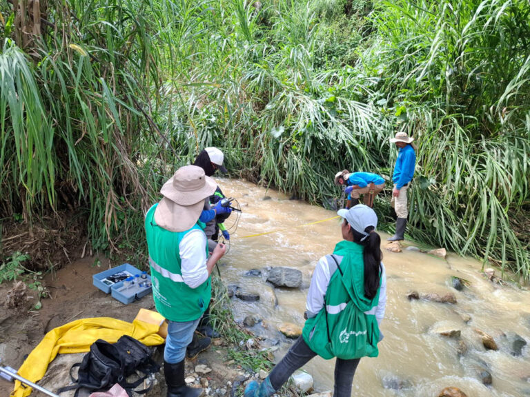 Imagen de funcionarios tomando medidas de un río