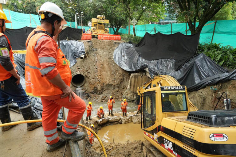 Imagen de obreros en obra con maquinaria amarilla