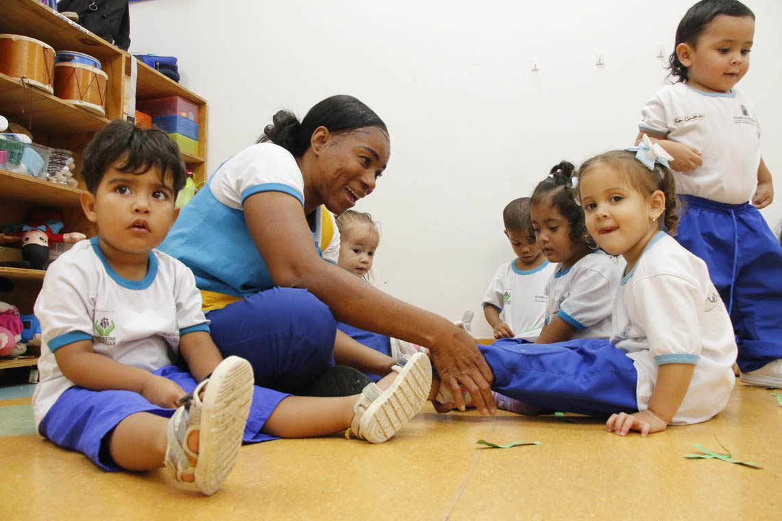 Imagen de docente jugando con niños de Buen Comienzo