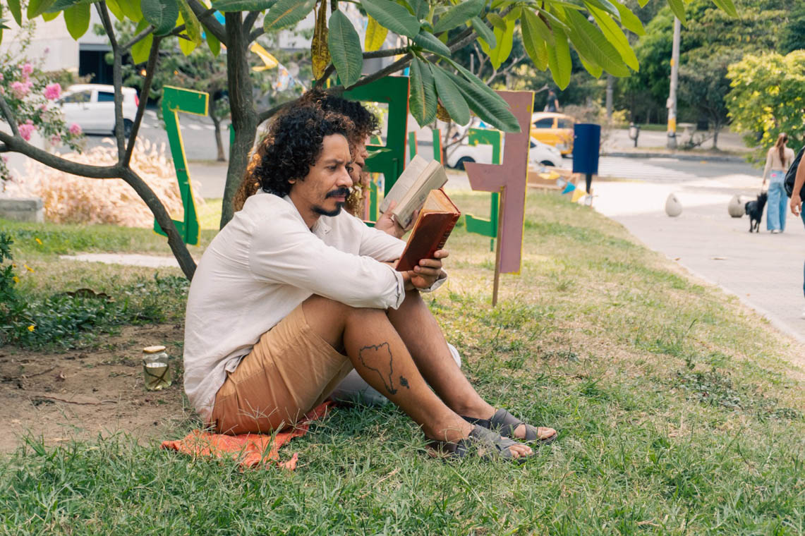 Imagen de dos personas leyendo en una zona verde