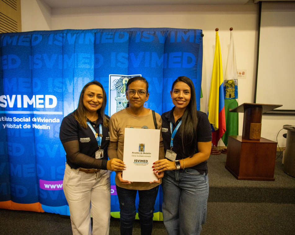Imagen de funcionarias de Isvimed entregando documento a ciudadana
