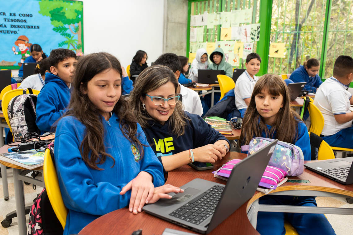 Imagen de joven estudiante frente a un computador en salón de clases