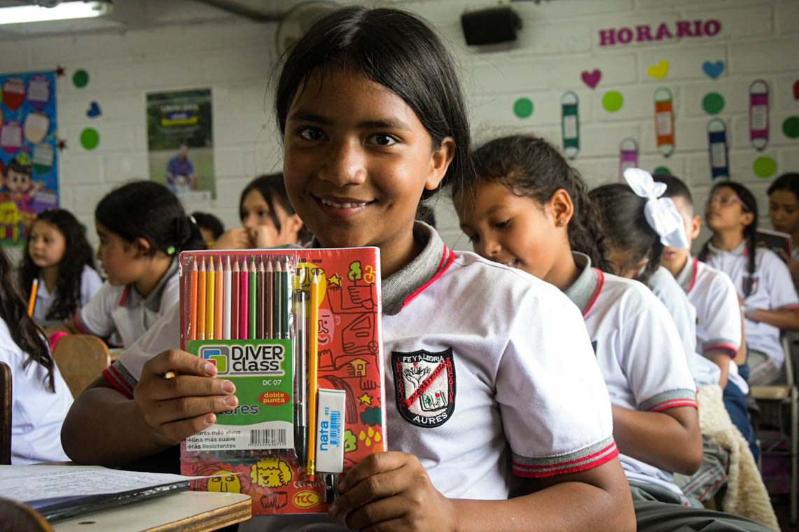 Imagen de niña sonriendo con un cuaderno nuevo