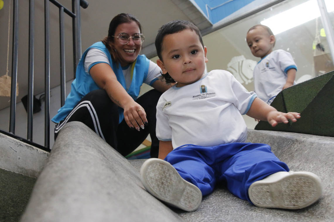 Imagen de niño y docente de Buen Comienzo jugando