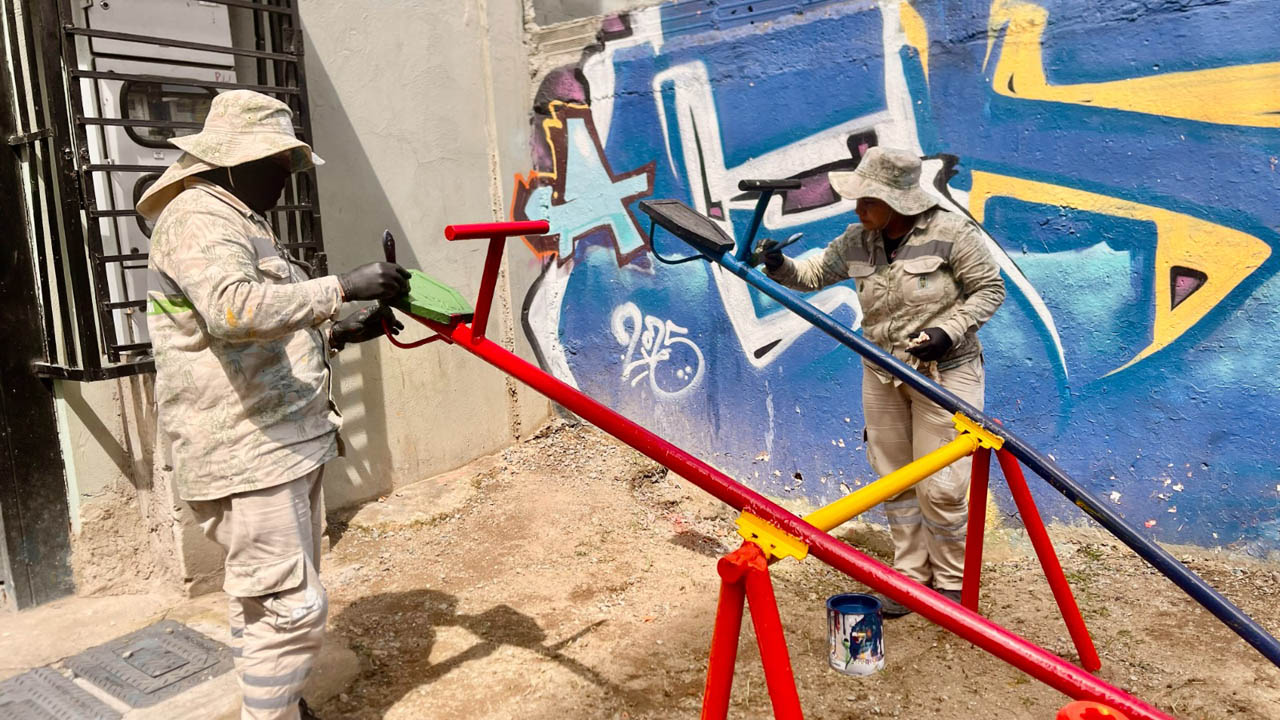 Imagen de obreros pintando un juego infantil