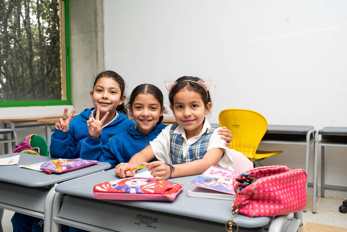 Imagen de tres niñas en un salón de clases