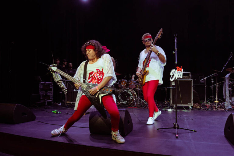Imagen de unos guitarristas tocando en el escenario