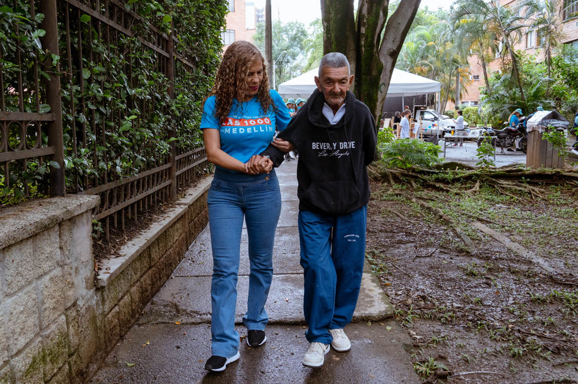 Imagen de voluntaria caminando con adulto mayor