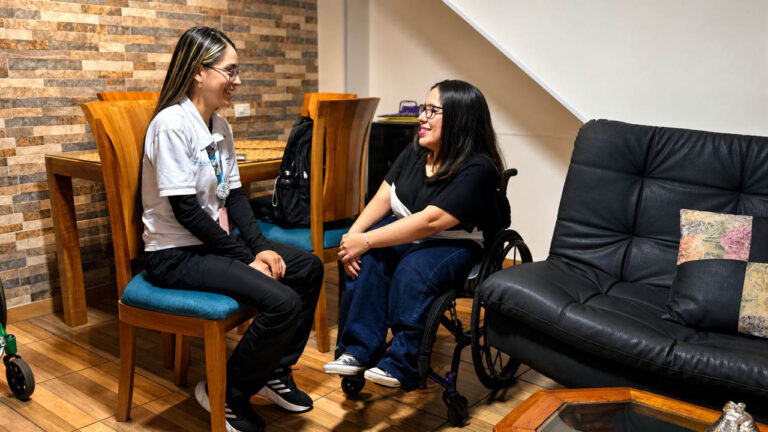 Imagen de dos mujeres hablando, una en silla de ruedas