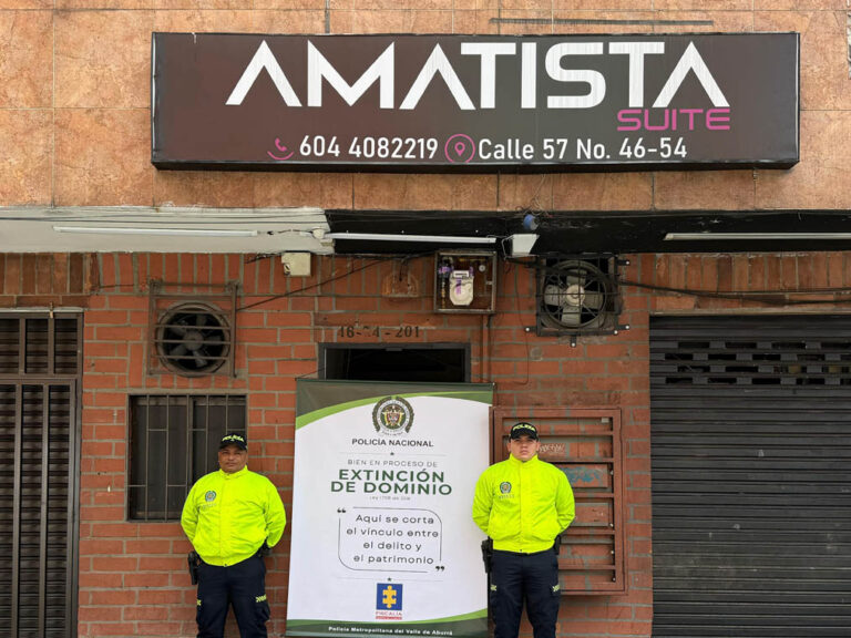 dos policías en bien con extinción de dominio