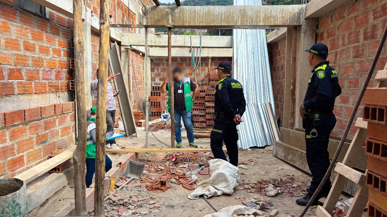 Imagen de policías y funcionarios en una construcción