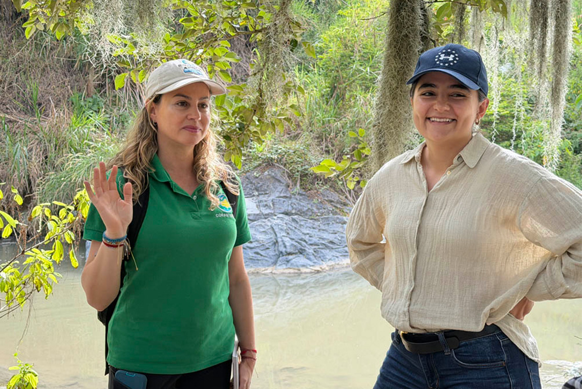 Imagen de funcionarias de Corantioquia sonrientes en una quebrada