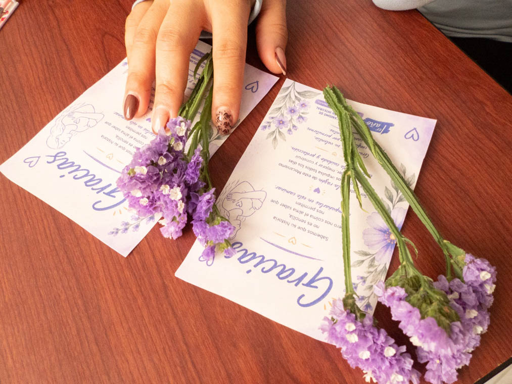 Imagen de manos de una mujer con dos cartas en una mesa