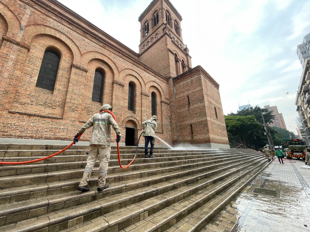 Imagen de funcionarios limpiando acera de iglesia