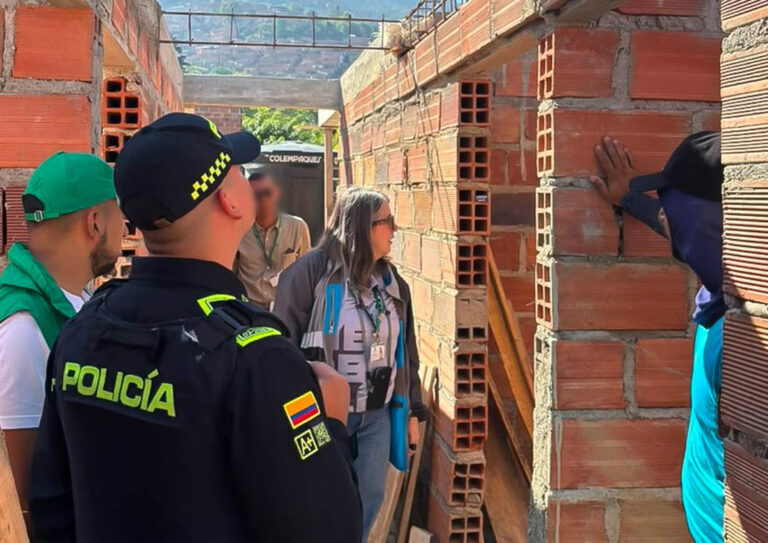 Imagen de policía y funcionarios en una construcción