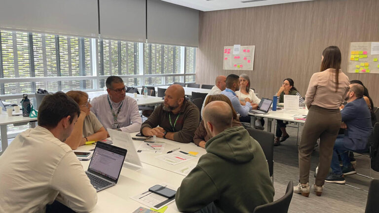 Imagen de grupo de personas reunidas en mesas de trabajo