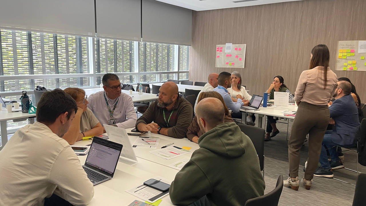 Imagen de grupo de personas reunidas en mesas de trabajo